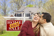 Couple in Front of Sold Real Estate Sign and House