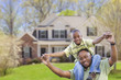 Playful African American Father and Son In Front of Home