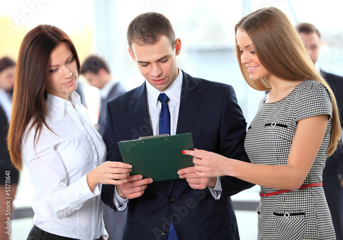 Photo: Happy business team discussing together their business strategy Happy business team discussing together their business strategy