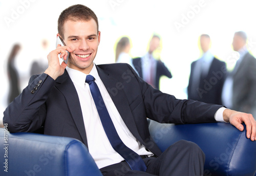 Photo: Young businessman enjoying a conversation over cellphone Young businessman enjoying a conversation over cellphone