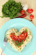 Cooked spaghetti carefully arranged in  heart shape and topped