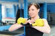 Happy young woman exercising with kettle bell weight