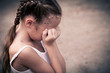 one sad woman sitting on the floor near a wall and holding her h