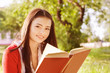 Photo: beautiful girl reads book in a park beautiful girl reads book in a park