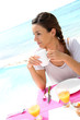 Portrait of brunette girl having coffee by the beach