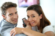Smiling couple watching movie on Tv