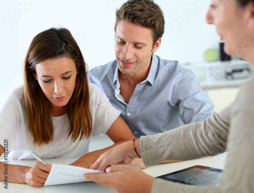 Photo: Couple signing real-estate contract Couple signing real-estate contract