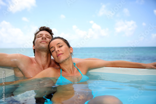 Photo: Couple relaxing in swimming pool Couple relaxing in swimming pool