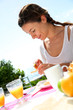 Cheerful woman eating toasts for breakfast