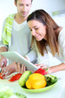 Couple in home kitchen looking for lunch recipe