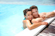 Portrait of cheerful couple in swimming-pool