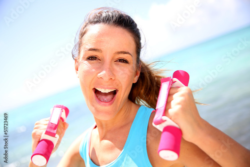 Photo: Cheerful girl lifting weights Cheerful girl lifting weights
