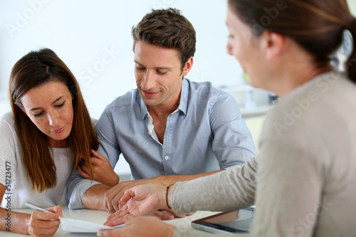 Photo: Couple signing real-estate contract Couple signing real-estate contract