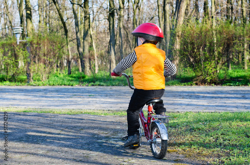 Photo: Little boy riding away from the viewer Little boy riding away from the viewer