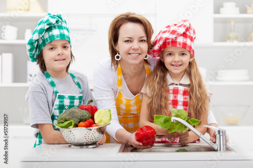 Photo: Woman washing the vegetables with the kids Woman washing the vegetables with the kids