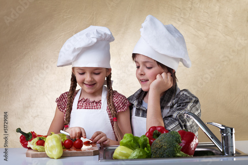 Photo: Kids cutting vegetables for a salad Kids cutting vegetables for a salad