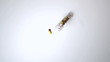 Jar of pills falling onto white surface