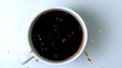 Sugar cube falling in cup of coffee