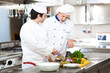 Two chefs cooking in a restaurant kitchen