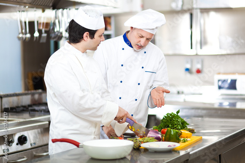 Photo: Two chefs cooking in a restaurant kitchen Two chefs cooking in a restaurant kitchen