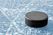 Photo: black hockey puck on ice rink black hockey puck on ice rink