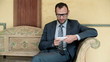 Businessman sitting on bench in luxury hotel using mobilephone, 
