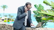 Angry businessman in tourist resort talking on cellphone, steadi