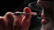 Man lighting a joint, close up on black