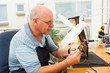 Photo: senior electrician examining a ciruit board senior electrician examining a ciruit board