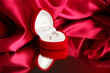 Beautiful box with wedding ring on red silk background