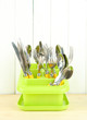 Knives, spoons, forks in plastic container for drying,