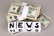 White paper cubes labeled "News" with money on grey background