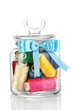 Glass jar containing various colored thread isolated on white