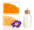 Colorful beads heap in boxes and glass bottle isolated on white