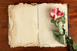 Photo: Open old book and rose on wooden background Open old book and rose on wooden background