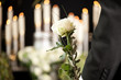 Grief - man with white roses at urn funeral
