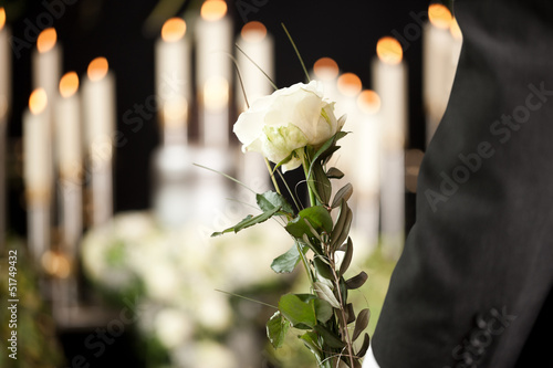 Photo: Grief - man with white roses at urn funeral Grief - man with white roses at urn funeral