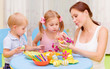 Little kids with teacher painted Easter eggs