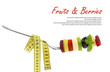 Fresh mixed slices of fruits on a fork with measuring tape
