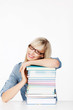 frau legt kopf auf bücherstapel