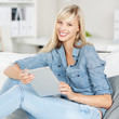 entspannte frau mit tablet zuhause auf dem sofa