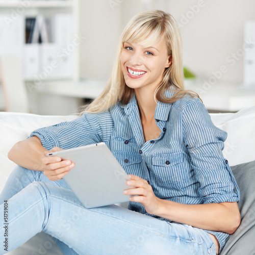 Photo: entspannte frau mit tablet zuhause auf dem sofa entspannte frau mit tablet zuhause auf dem sofa