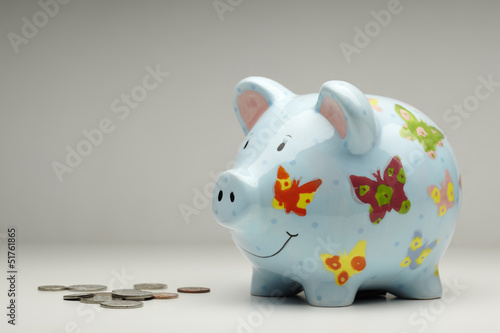 Photo: Colourful piggy bank with money isolated Colourful piggy bank with money isolated