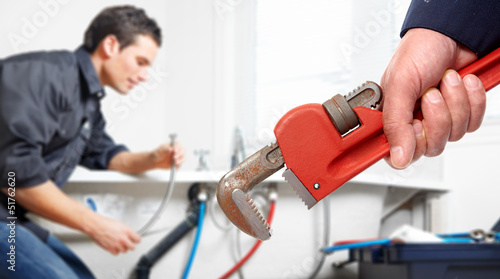 Photo: Hand with wrench. Plumber. Hand with wrench. Plumber.