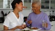 Senior woman with caregiver taking medication