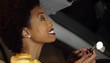 African American woman putting on make up