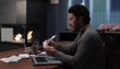 Hispanic man at home with laptop sorting bills