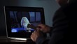 Black man holding bone while teleconferencing with dog