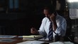 Businessman in the evening conversing on telephone and taking notes