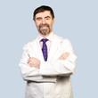Photo: Portrait of happy middle-aged dentist on a pale background Portrait of happy middle-aged dentist on a pale background